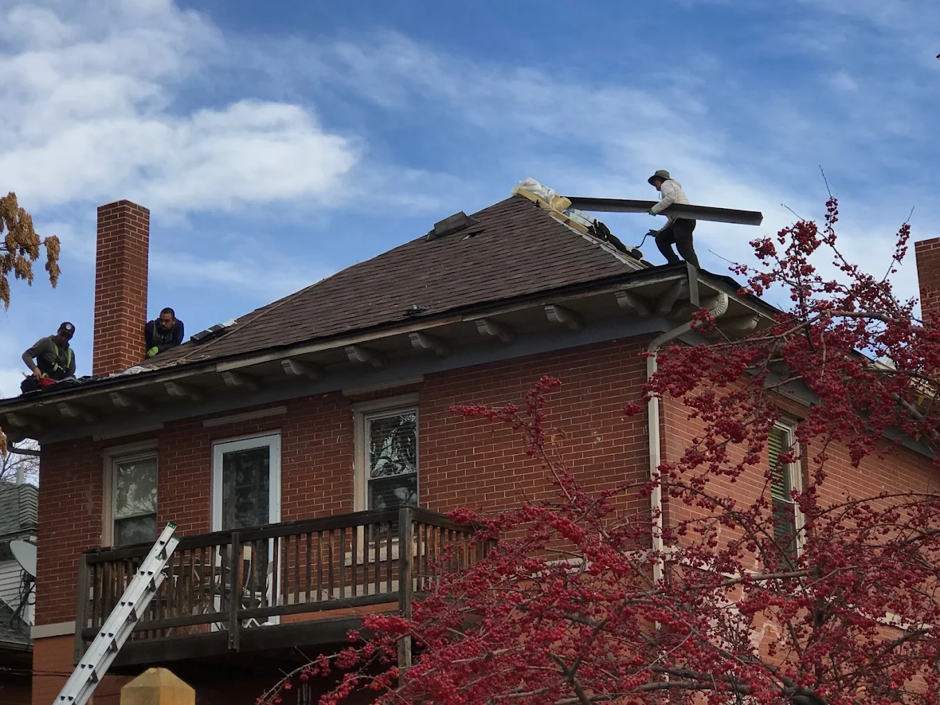DLMRF crew tearing off old shingles during a roof replacement on a brick home in Denver