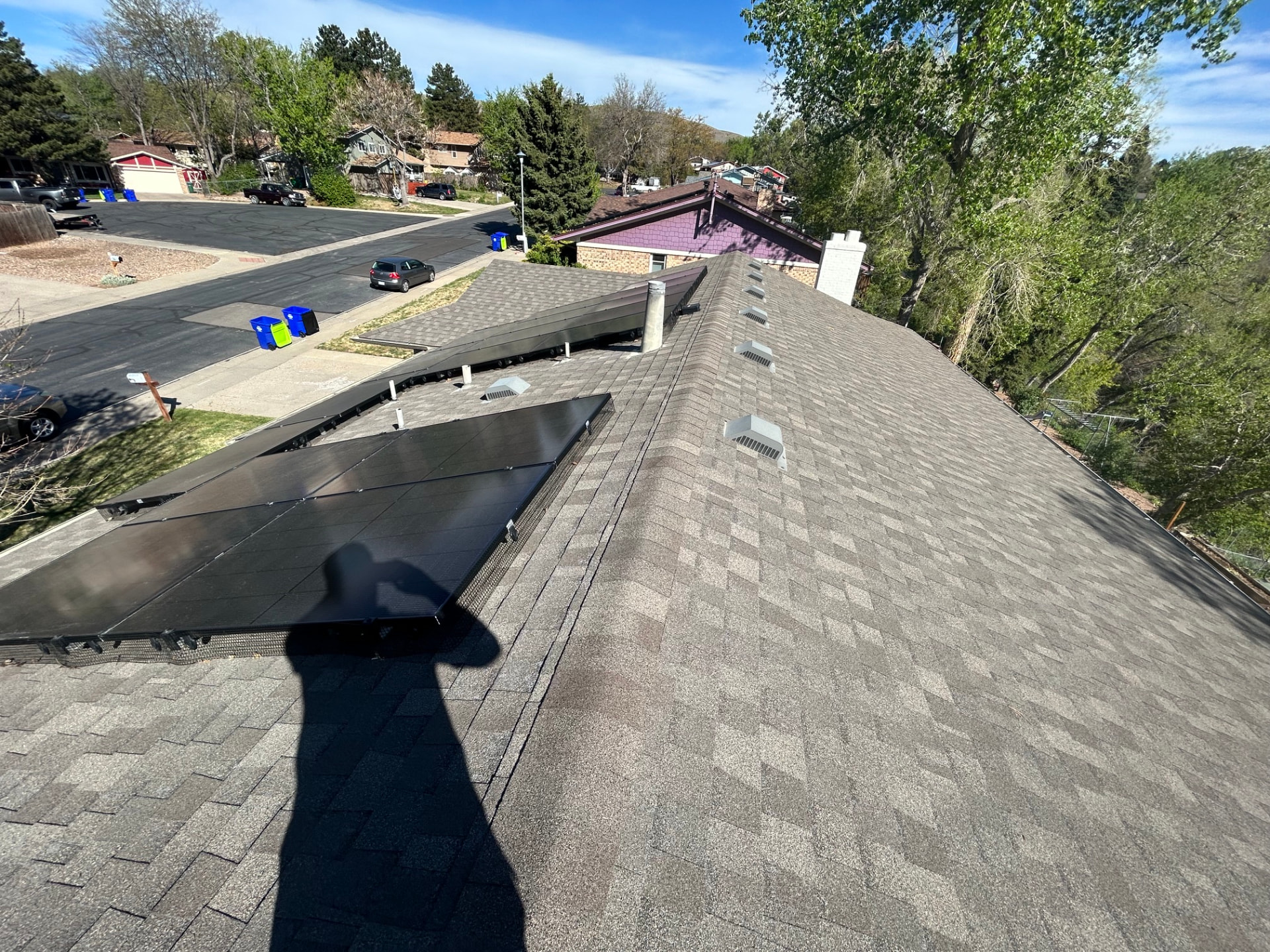 Asphalt shingle roof replacement around existing solar panels on a Colorado home